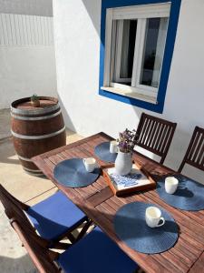 a wooden table with blue plates and cups and a barrel at A Casa Azul in Vaiamonte