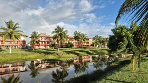 a view of a resort with palm trees and a pond at Apart Resort Vila das Águas Veraneio in Estância