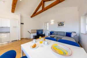 a living room with a white table and blue chairs at Whispering Views House Old Town in Dubrovnik +41 photos