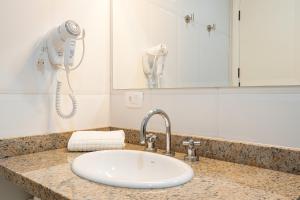 a bathroom counter with a sink and a hair dryer at Pousada Sol da Mantiqueira in Campos do Jordão +69 photos