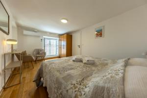 a bedroom with a bed and a chair and a window at Whispering Views House Old Town in Dubrovnik