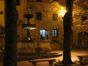 a fountain in front of a building at night at Le Pietre Antiche in Castiglione dʼOrcia