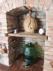 een bakstenen oven met een grote groene vaas op een plank bij Le Pietre Antiche in Castiglione dʼOrcia