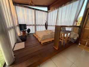 a bedroom with a bed and a chair on a balcony at Chalé e Cabana Taubate in Taubaté