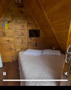 a bedroom with a bed in a wooden cabin at Chalé e Cabana Taubate in Taubaté +36 photos