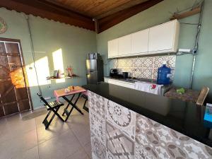 a kitchen with a counter and a table in it at Chalé e Cabana Taubate in Taubaté