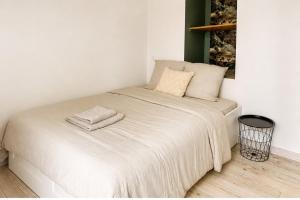 a white bed with two towels on top of it at Studio Chaleureux in Langon