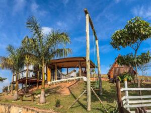 a house on a hill with palm trees at Chalé e Cabana Taubate in Taubaté