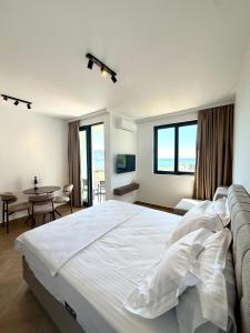a bedroom with a large white bed and a table at Maresa 8 in Čanj