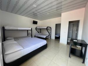 a bedroom with two bunk beds and a desk at EL PARAISO DE GAIRA in Santa Marta