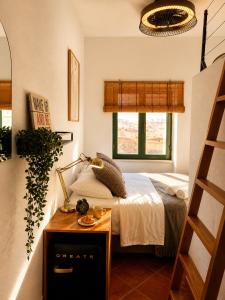 a small bedroom with a bed and a table at Refúgio No16 Ocean Air & Rooftop Flair in Albufeira