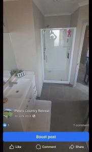 a bathroom with a shower and a white sink at Peter Country Retreat in Midhirst