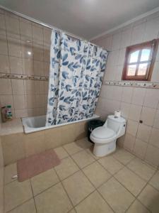a bathroom with a toilet and a tub and a shower curtain at Pieza con vista al mar in La Serena +12 photos