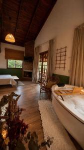 a room with a bed and a tub in a room at Chalé na montanha com vista e lareira Mantiqueira in Costas