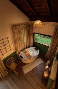 a bathroom with a bath tub and a window at Chalé na montanha com vista e lareira Mantiqueira in Costas +39 photos