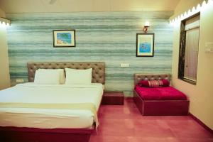 a bedroom with a bed and a bench in it at Siddhant Hill Resort in Revadanda +92 photos