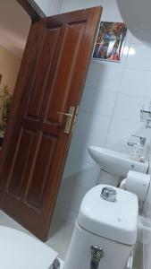 a bathroom with a wooden door and a toilet at Providence Guest house and Catering Services 01 in Abidjan +29 photos
