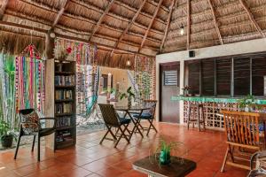 a living room with a table and chairs and a book shelf at Hotel Barrio Latino in Playa del Carmen