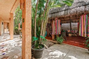 a porch of a house with a palm tree at Hotel Barrio Latino in Playa del Carmen