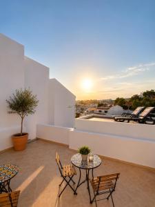 a patio with a table and chairs on a roof at Refúgio No16 Ocean Air & Rooftop Flair in Albufeira