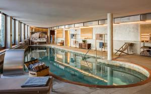 a large swimming pool in a building with a house at Hotel Hermitage Relais & Châteaux in Breuil-Cervinia