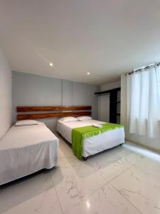 a bedroom with two beds and a window at Hotel Amazonas Real in Leticia