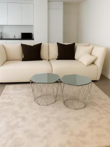 a living room with a couch and two glass tables at PepinA'S Home in Martigny-Ville