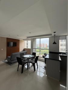 a living room with a table and chairs and a couch at Barranquilla Prime Apartment in Barranquilla