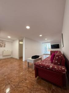 a living room with a red couch and a table at Casa Tul Studio Apartment in Maspalomas