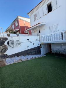 a white house with a green lawn in front of it at Casa Tul Studio Apartment in Maspalomas