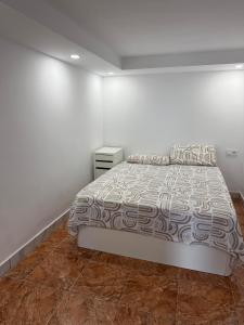 a bedroom with a bed and a white wall at Casa Tul Studio Apartment in Maspalomas