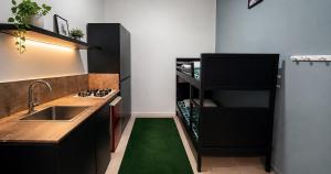 a kitchen with a sink and a counter with a green rug at Stay Central Malta in San Ġwann