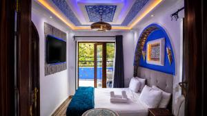 a hotel room with a bed and a tv at Riad Zaitouna Chaouen in Chefchaouen