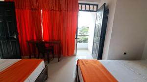 a bedroom with two beds and a desk and a window at Hotel Rios in Garzón