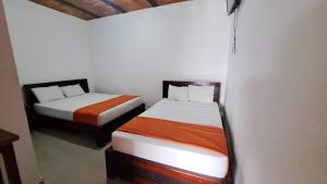 two beds sitting next to each other in a room at Hotel Rios in Garzón