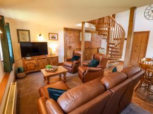 a living room with a leather couch and a television at Barn Owl in Louth