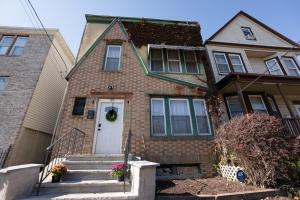a brick house with a white door and stairs at Spacious 3BR Near NYC with Workspace in Newark