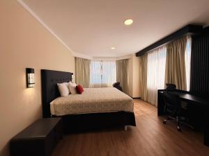a hotel room with a bed and a desk at Taormina Hotel y Casino in San José