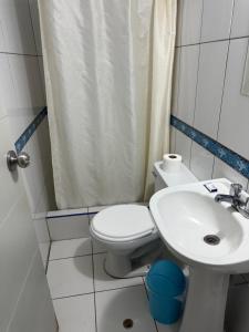 a small bathroom with a toilet and a sink at HOTEL LUCERO REAL Tacna in Tacna