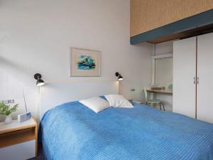 a bedroom with a bed with a blue blanket at 4 star holiday home in Væggerløse in Bøtø By +31 photos