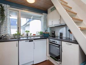 a kitchen with white cabinets and a sink and a window at 4 star holiday home in Væggerløse in Bøtø By