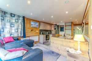 a living room with a couch and a kitchen at Spacious Ski-In Out apartment with Mountain Views in Val Thorens