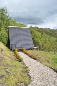 a building sitting on top of a hill next to a gravel road at Tierra Viva By Astrid in Cucunubá