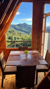 a table and chairs in a room with a large window at Tierra Viva By Astrid in Cucunubá +12 photos