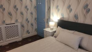 a bedroom with a white bed and a blue wall at Ansty homes in Wyken