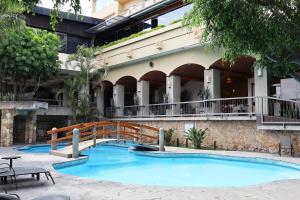 a swimming pool in front of a building at Hotel Fortin Plaza in Oaxaca City