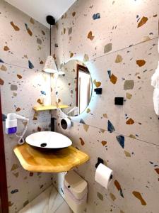 a bathroom with a rock wall with a sink and a mirror at Creta Star Apartments in Agia Galini +37 photos