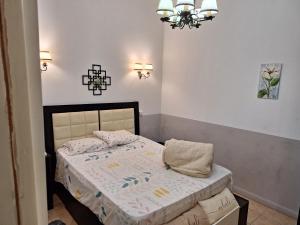 ein kleines Schlafzimmer mit einem Bett und einem Kronleuchter in der Unterkunft LÜr4 in Río Cuarto