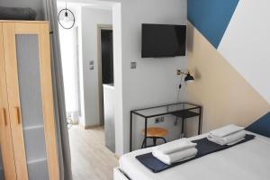 a bedroom with a bed with a tv on the wall at Artemis Boutique House in Artemida