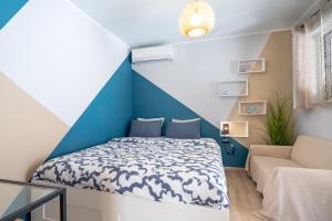 a blue and white bedroom with a bed and a couch at Artemis Boutique House in Artemida
